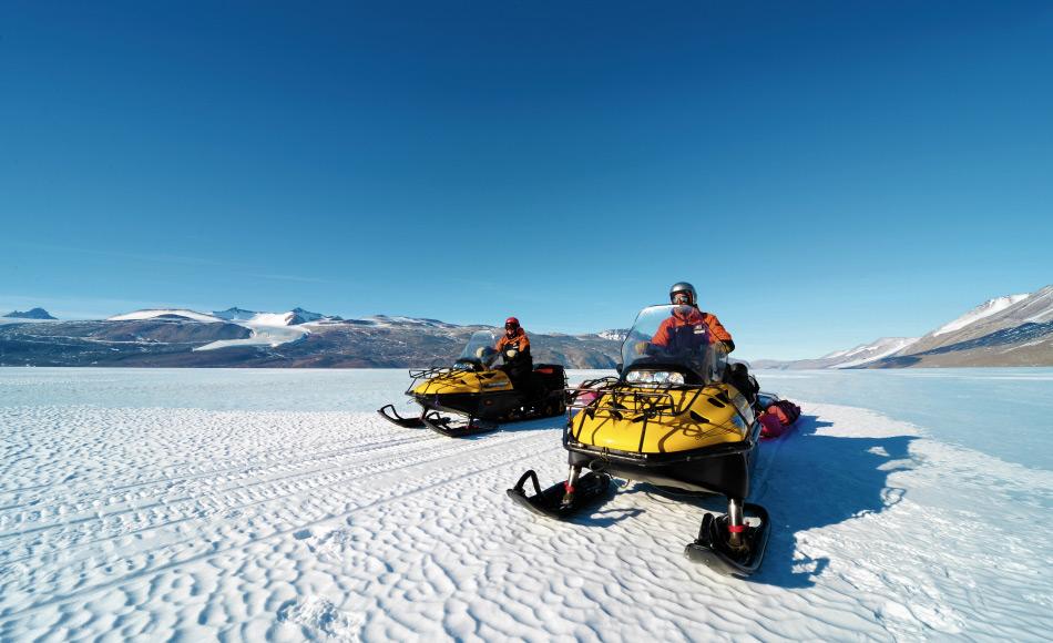 Das Reisen in der Antarktis ist während des Sommers relativ einfach. Hier fahren zwei Wissenschaftler auf Skidoos zu ihrem Forschungslager auf dem Taylor Gletscher, aber Bedingungen im Winter werden neue Herausforderungen für die Forscher bringen. (Foto: Katja Riedel)